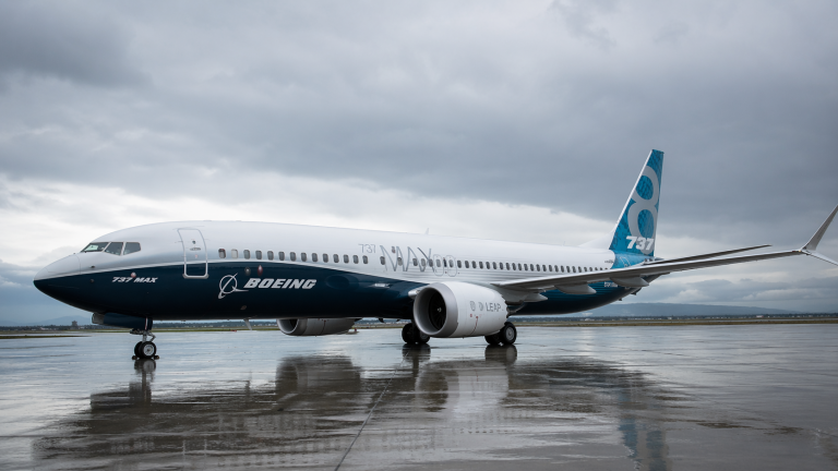 Boeing 737 MAX на мокрой взлетной полосе в пасмурную погоду, крупный план самолета.